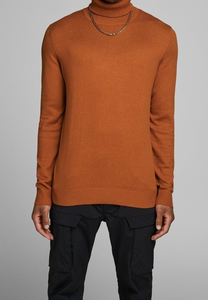 Pull à col roulé moutarde en tissu tricoté doux avec ourlet côtelé. Associé à un pantalon cargo foncé avec plusieurs poches et coupe fuselée.