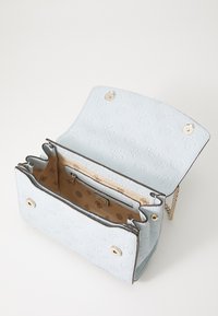 Light blue textured leather handbag with gold hardware, featuring an open top, interior compartments, and an embossed logo pattern.