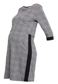 Gravidklänning i svart och vitt rutmönster, med rund halsringning, trekvartslånga ärmar och svarta sidopaneler som accent.