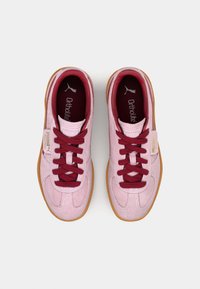 Rosa Wildledersneaker mit kastanienbraunen Schnürsenkeln, gepolsterten Einlegesohlen und Gummisohlen. Verfügt über ein Logo auf der Zunge und ein Etikett an der Seite.