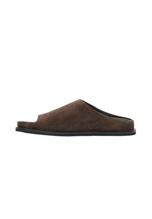 Brązowe mule zamszowe z odkrytymi palcami, płaską czarną podeszwą, stylem slip-on i niskim tyłem dla łatwego zakładania.