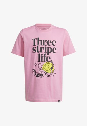 Deux enfants portent des t-shirts roses assortis avec un motif graphique et le texte « Three stripe life ». L'un porte un short gris, l'autre un short noir.