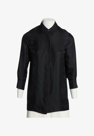 Chemise noire à manches longues avec un motif subtil, col classique et boutons avant cachés sur un buste de mannequin blanc.