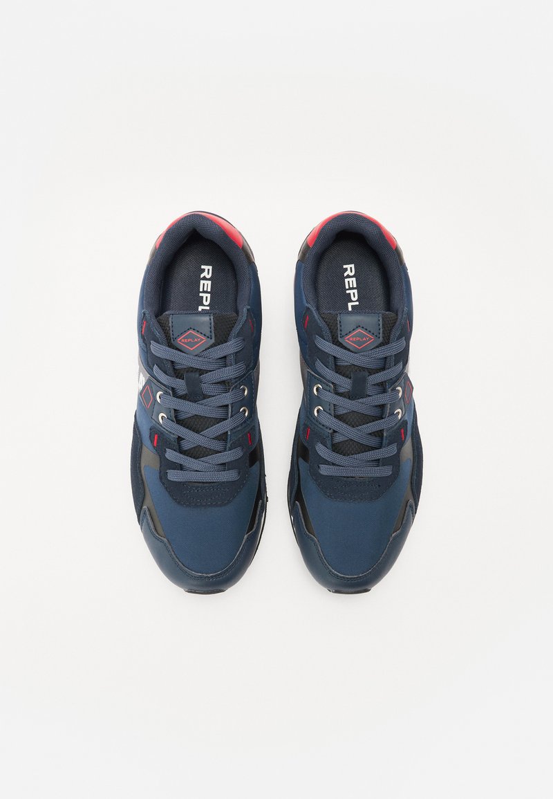Sneakers blu navy con tessuto in rete, suola in gomma, accenti rossi e lacci. Presentano un logo sulla linguetta e dettagli riflettenti sui lati.