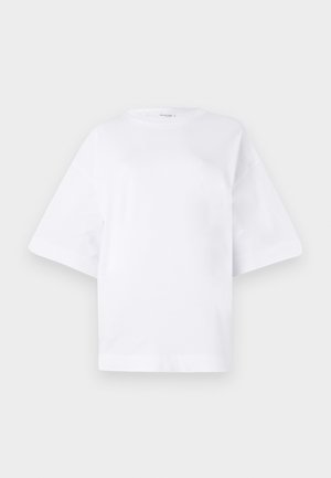 Valkoinen iso t-paita, joka on valmistettu puuvillasta. T-paidassa on lyhyet hihat, pyöreä pääntie ja suora helma ilman minkäänlaisia kuvioita tai koristuksia.