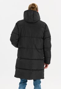 Sort puffjakke med hætte, der har et quiltet design og en forlænget krop. Stoffet ser glat og let skinnende ud.