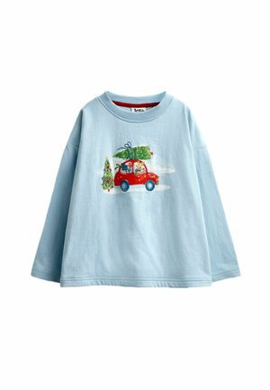 Light blue long-sleeve shirt with a red car carrying a Christmas tree and gifts, and a decorated Christmas tree beside it.