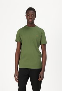 T-shirt verde de algodão com decote redondo, mangas curtas e detalhe bordado laranja no peito. Design simples e com corte reto.