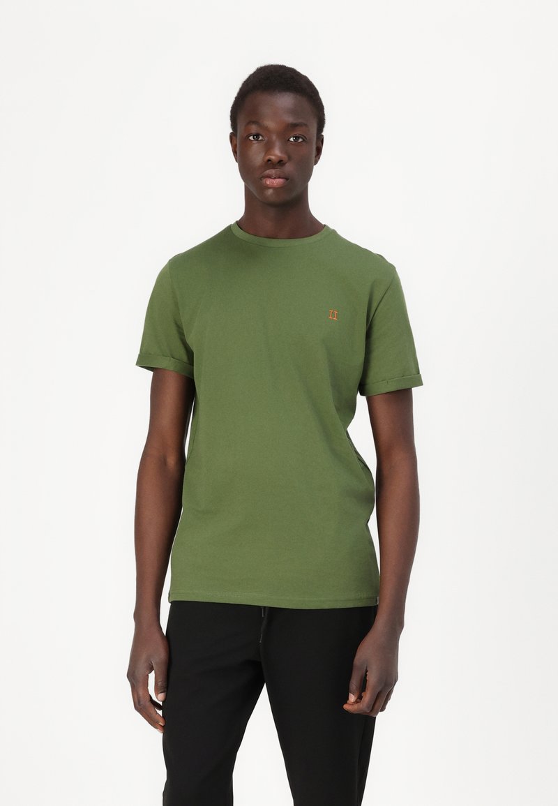 T-shirt verde de algodão com decote redondo, mangas curtas e detalhe bordado laranja no peito. Design simples e com corte reto.