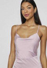 Ljusrosa satin camisol med tunna axelband, rundad halsringning och slät yta. Enkla design med figursydd bodice och sömdekoration.