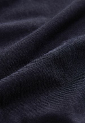 Tejido de algodón azul marino oscuro con una textura suave, que presenta un ligero acanalado. El material parece ligeramente arrugado, lo que destaca su caída suave.