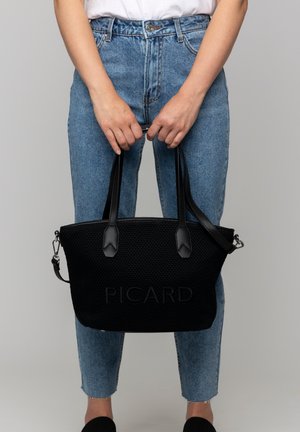 Schwarze gewebte Tragetasche mit doppelten Griffen, ausgestattet mit einer strukturierten Oberfläche, geprägtem Branding und einem abnehmbaren Schultergurt.