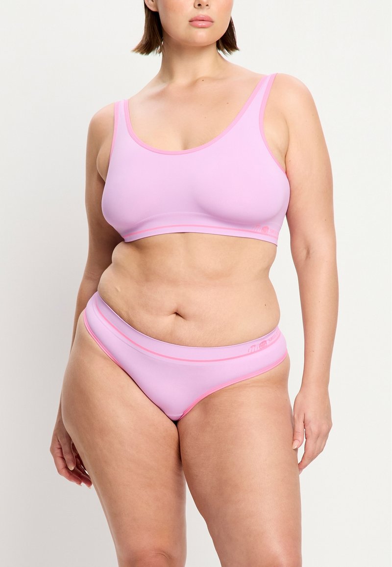 Hellrosa Bralette mit einem runden Ausschnitt und breiten Trägern, kombiniert mit passenden Bikinihosen mit pinkem Besatz und glatter Textur.