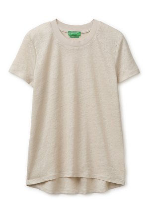 T-shirt beige à manches courtes avec col rond, ourlet arrière légèrement plus long et étiquette de marque verte visible à l'intérieur du col.