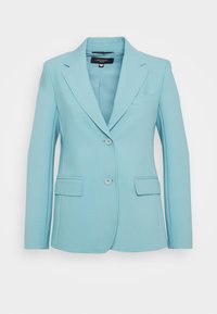 Blazer azzurro chiaro su misura in tessuto liscio, con rever a lancia, due tasche frontali e chiusura con un solo bottone.