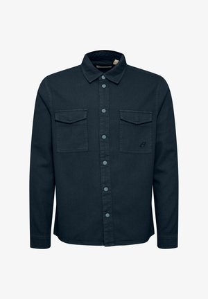 Sötétkék farmering, galléros nyakkal, két mellzsebbel és gombos elejével. Kék gombokkal és diszkrét márkázással rendelkezik.