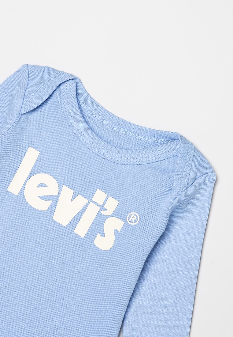 Body de bebé azul claro con mangas largas y logo blanco de Levi’s impreso en el pecho.