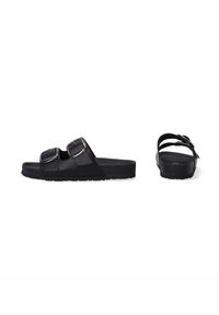 Black sandals featuring dual adjustable buckle straps, a flat sole, and a smooth matte texture with a sturdy rubber base.
