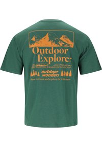 T-shirt vert avec un motif de montagne orange et le texte : "Explorateur en plein air", "Whistler", "L'aventure commence où le sentier s'arrête", ainsi que des silhouettes d'arbres.
