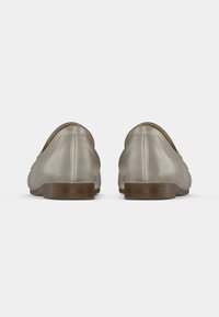 Beežide nahast mokassiinid sileda tekstuuriga, ümarate varvastega, madala puidust kontsaga ja õmblustega detailidega seljaõmbluse ääres.