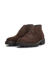 Stivaletti in suede marrone con punta tondeggiante, chiusura con lacci e suola in gomma spessa con scanalature profonde per migliorare la trazione.
