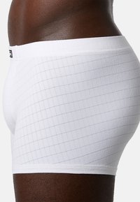 Vita boxershorts med ett subtilt rutmönster, tillverkade av mjukt tyg, med en slät midjeband och en åtsittande design.