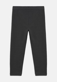 Μαύροι κολάν από μαλακό, ελαστικό ύφασμα. Διαθέτουν λεία μέση και εφαρμοστή σιλουέτα χωρίς εμφανείς ραφές ή σχέδια.