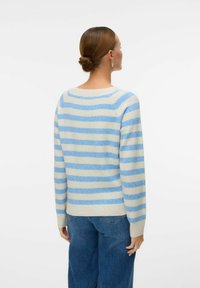 Pull rayé en crème et bleu clair. Il présente une coupe décontractée, un col large et des poignets côtelés. La vue arrière montre des manches longues et une texture douce.