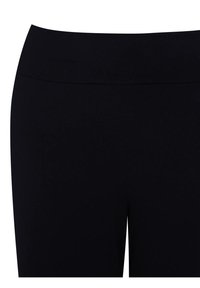 Primo piano di leggings neri a vita alta che mostrano un tessuto liscio e una vita larga senza cuciture o loghi visibili.