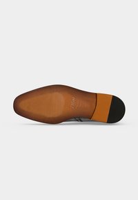 Semelle d'une chaussure habillée en cuir marron avec une zone d'orteil texturée, une section médiane lisse et un patch de talon en caoutchouc noir marqué Zign, taille 42.