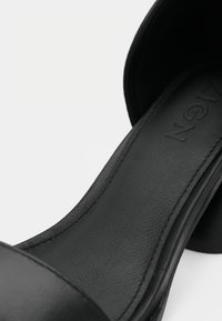 Schwarze High-Heelsandale mit einem glatten Lederoberteil, rundem offenen Zehenbereich und einer konturierten Fußbett, mit dezenten Nähten und einem stabilen Absatz.