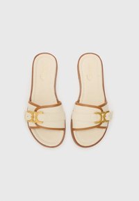 Beige canvas slide sandals with brown leather accents and a gold buckle detail. Flat sole, open toe, and a stitched design on the upper.