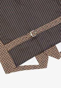 Tessuto a motivo houndstooth marrone e bianco con una sezione a strisce scure, dotato di una fibbia argentata e una finitura texturizzata.