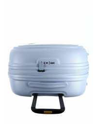 Valigia rigida di color azzurro chiaro, dotata di chiusura con zip, lucchetto combinato integrato e manico nero estensibile. Superficie liscia.