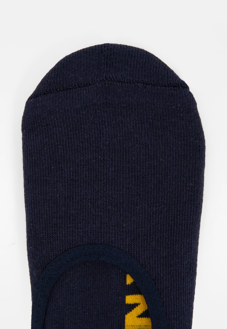 Granatowa bawełniana skarpetka o prążkowanej fakturze, zaokrąglonym palcu i żółtym wzorze tekstowym. Prosty design, bez widocznych znaków marki czy akcentów sprzętowych.