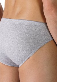 Grå bomullsboxershorts med en mjuk textur, låg midja och minimala sömdetaljer. Tyget verkar mjukt och elastiskt.