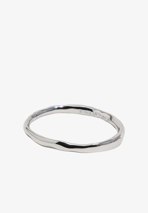 Strieborný skrútený kovový náramok s hladkým, nepravidelným tvarom a jemným vyrytým logom na vonkajšej strane.