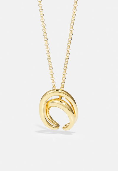 Le collier doré présente un design de pendentif torsadé. La chaîne est composée de petits maillons entrelacés, ajoutant texture et éclat.