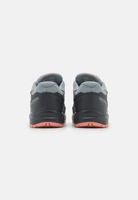 Zapatillas de correr para hombres con parte superior sintética gris, detalles en negro, colchón en el cuello y suela de goma rosa en contraste.
