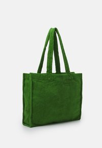 Zielona torba tote z dwoma uchwytami, prostokątny kształt, miękka tekstura i zszywane szwy, charakteryzująca się prostym, jednolitym kolorem.