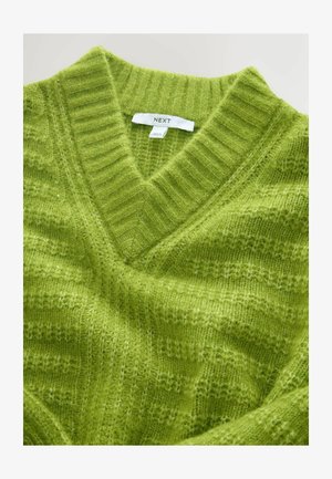 Maglione verde a collo a V lavorato a maglia con un motivo testurizzato, realizzato in materiale morbido. Presenta un'etichetta con la dicitura "NEXT" vicino al collo.