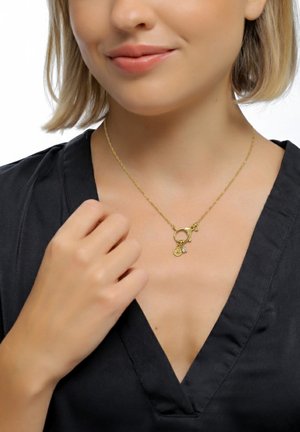 Goldkette mit einem runden Anhänger und Charms. Die Kette ist zart; der Anhänger enthält funkelnde Akzente und eine strukturierte Oberfläche.