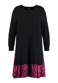 Haut noir en maille à manches longues, avec une jupe évasée à motifs violets et roses. Détail en bord-côte au col et à l'ourlet. Design décontracté.