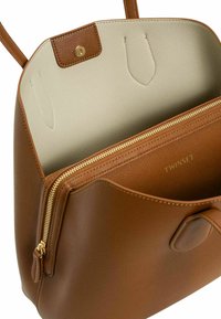 Borsa a mano in pelle marrone con una texture liscia, dotata di una tasca con zip, interno chiaro in contrasto e chiusura a bottone.