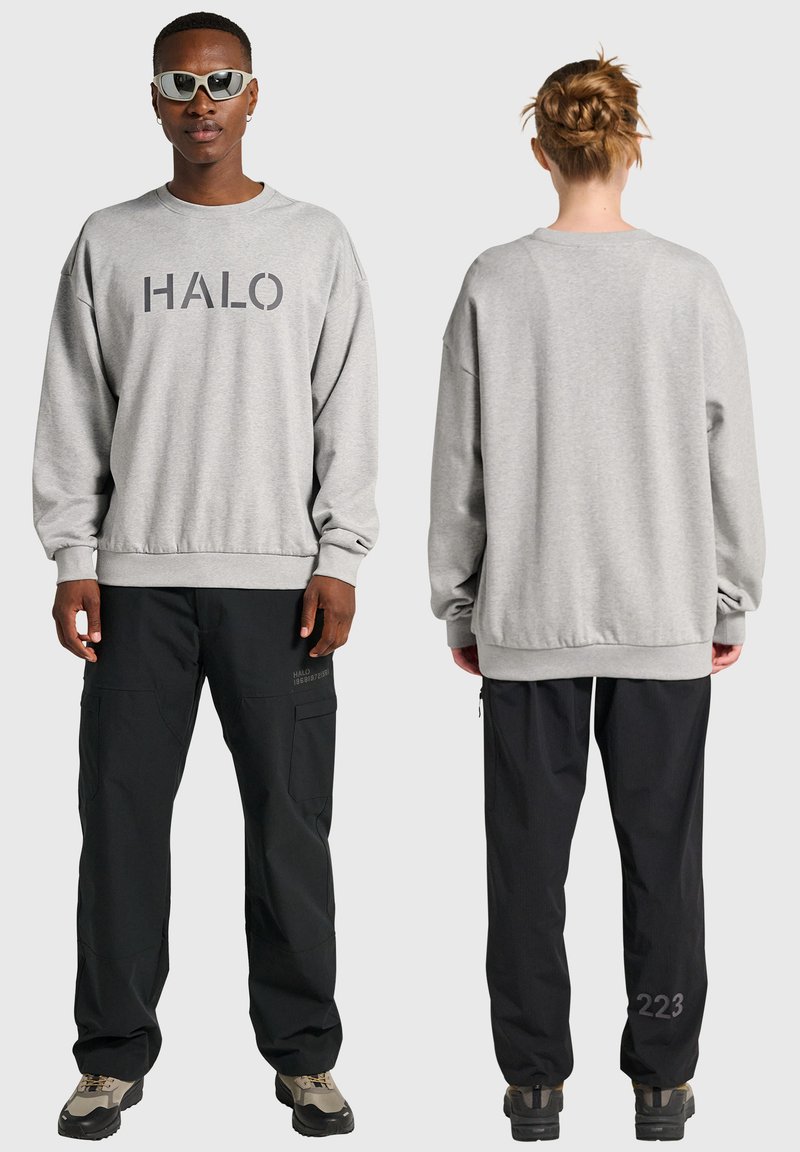 Grå sweatshirt med "HALO"-tryck, relaxed fit; kombinerad med svarta cargobyxor med fickor och detaljer baktill; skor med grå och svarta detaljer.