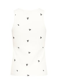 Top alb fără mâneci cu modele mici de cireșe negre împrăștiate pe un fundal simplu.