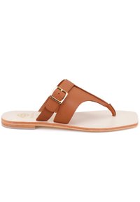 Braunes Leder-Flip-Flop-Sandale mit zwei Riemen, wobei einer eine goldene Schnalle hat, und einer hellen flachen Sohle. Minimalistisches Design mit glatter Textur.