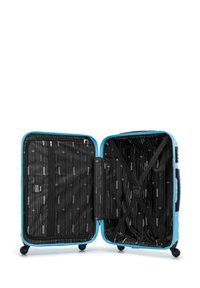 Valise rigide de couleur bleu vif, avec deux compartiments zippés, intérieur noir à rayures diagonales, et quatre roues pour une mobilité facile.