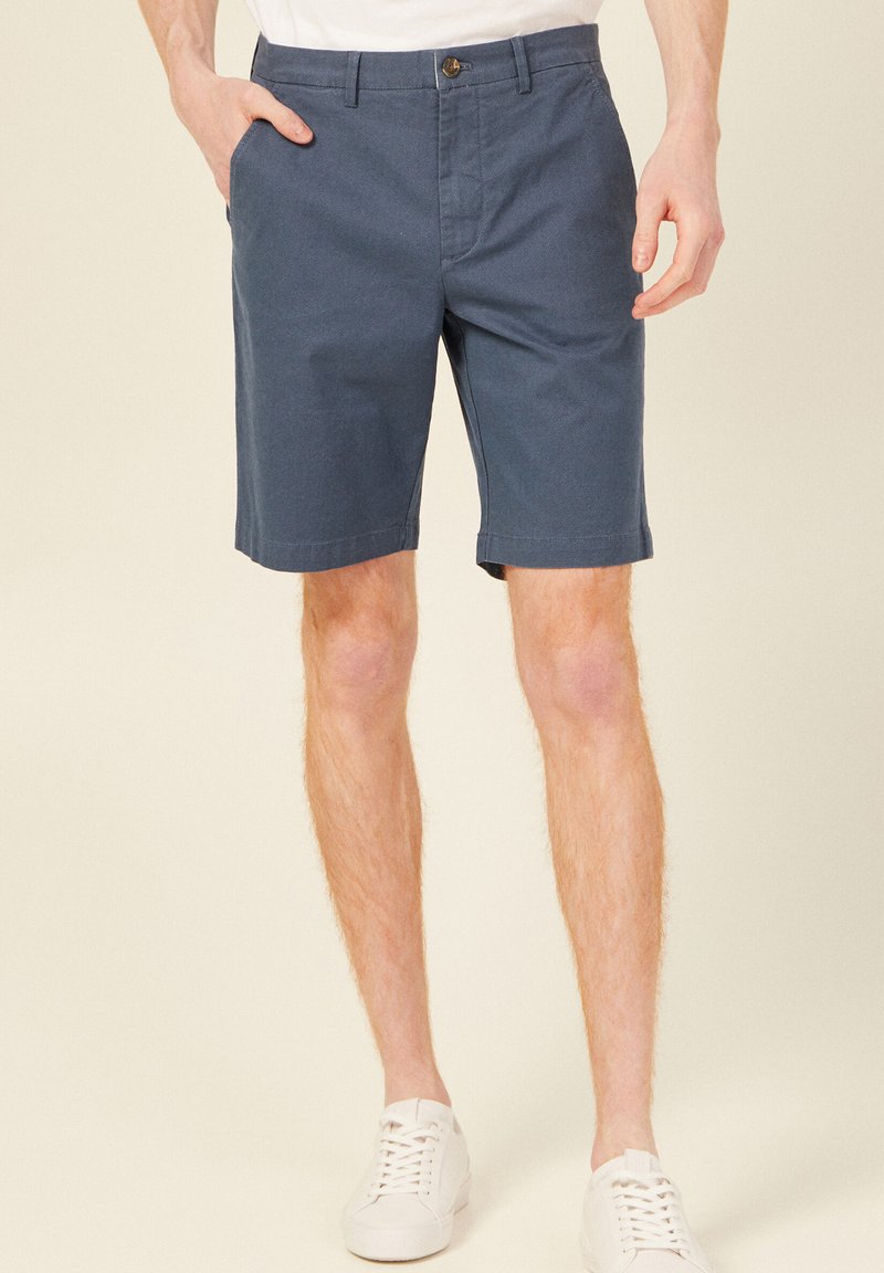 Mörkblå shorts med rak front, sidofickor och knappstängning. Tillverkade av bomullstyg, med en slät yta och skräddarsydd passform.