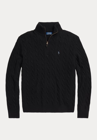 Juodas megztinis su pynėmis, pusiau užtrauktuku, raukšlėtomis rankogaliais ir maža siuvinėta logotipu ant krūtinės. Pagamintas iš tekstūruotos medžiagos.